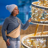 Woman in winter clothing standing next to a large, ornate golden structure.